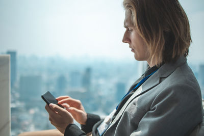 Side view of man using smart phone