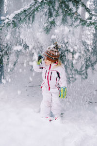 Full length of woman skiing on snow covered field