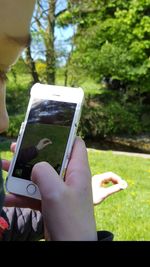 Midsection of woman photographing with mobile phone