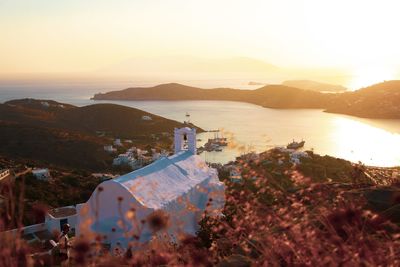 High angle view of church on mountain with sea in background against clear sky during sunset