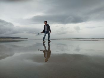 Man standing in lake against sky