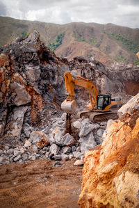 Serial view of a excavator working in a limestone quarry to extract raw material for cement 