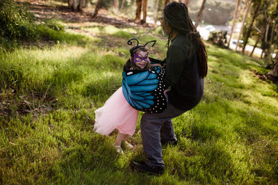 Uncle and niece in dress up playing in field