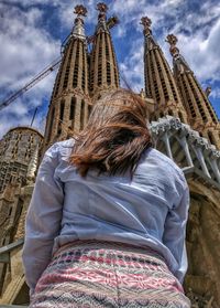 Low angle view of woman standing against barcelona cathedral