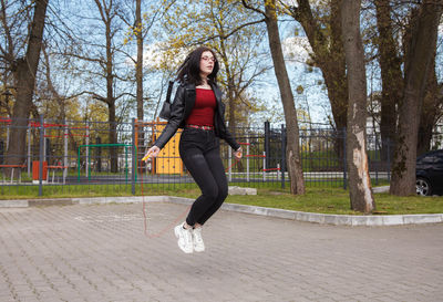 Full length of woman on footpath amidst trees