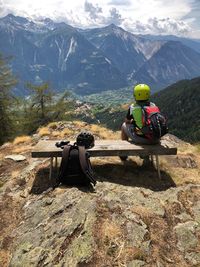 Rear view of people sitting on mountain range