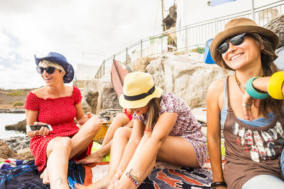 Happy friends sitting at beach