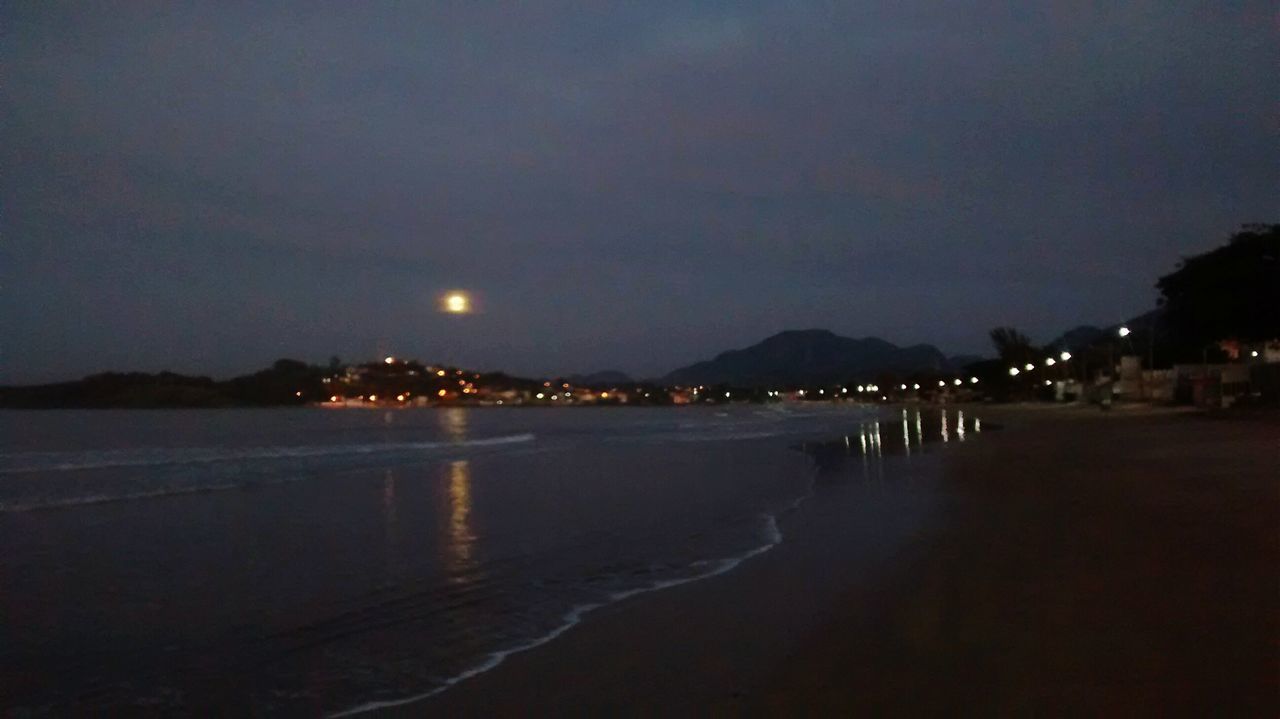 water, night, illuminated, beach, sea, sky, scenics, tranquil scene, shore, tranquility, beauty in nature, dusk, reflection, nature, mountain, idyllic, coastline, sand, outdoors, waterfront