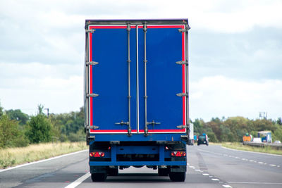 View of truck on road against cloudy sky