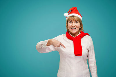 Portrait of smiling woman standing against blue background