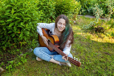 Portrait of young woman sitting on field