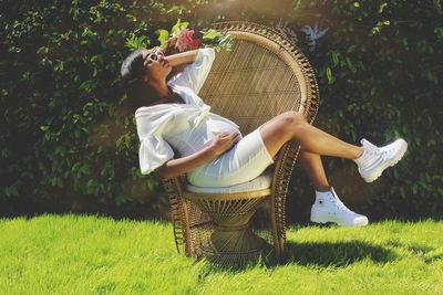 Full length of woman relaxing on grass outdoors