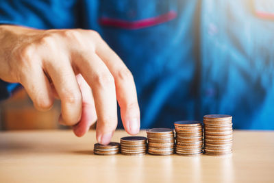 Close-up of hand holding coins on table