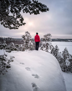 Man standing on snow covered landscape against sky