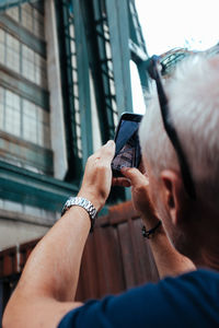 Midsection of man using mobile phone