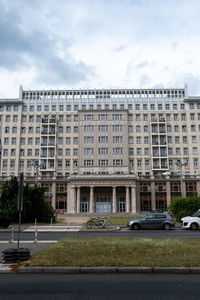 Building by road against sky in city