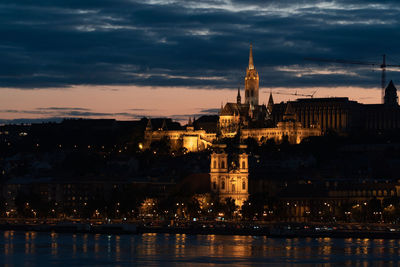 Illuminated buildings in city at waterfront