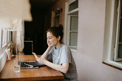 Young woman using laptop at home
