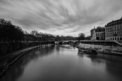 Bridge over river in city against sky