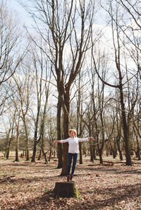 Silhouette of woman walking on tree trunk