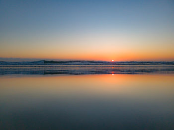 Scenic view of sea against clear sky during sunset