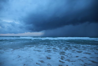 Scenic view of sea against storm clouds