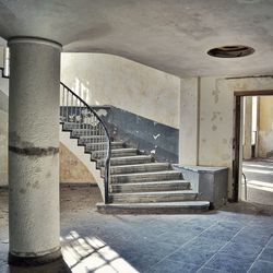 Staircases in abandoned room on sunny day