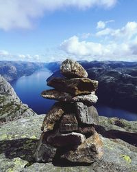 Stack of rock in lake against sky