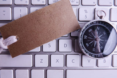 High angle view of navigational compass on keyboard