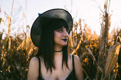 Portrait of young woman wearing hat on field