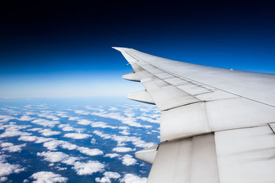 Airplane wing against blue sky