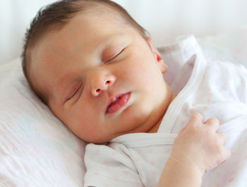 Close-up of baby sleeping on bed