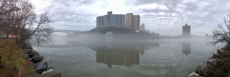 Reflection of buildings in city against sky