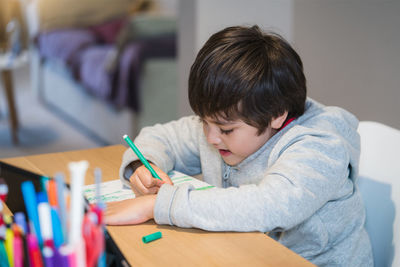 Boy sitting on table at home