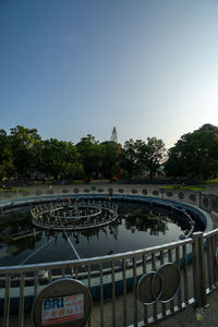 View of swimming pool by lake against sky