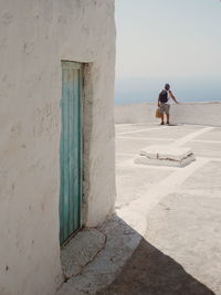 Rear view of backpack man on building terrace