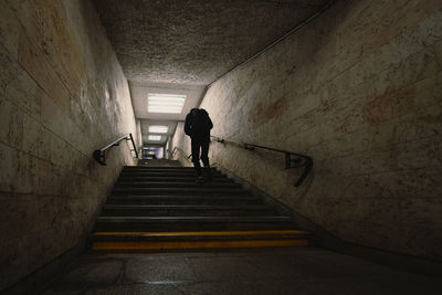 Rear view of man walking in tunnel