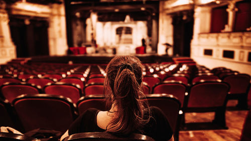 Rear view of woman sitting in chairs