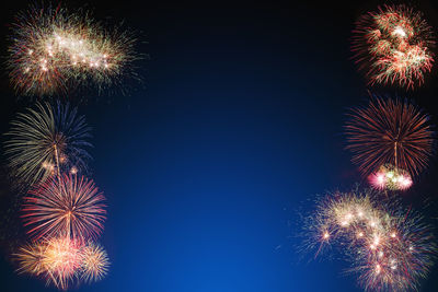 Low angle view of firework display at night