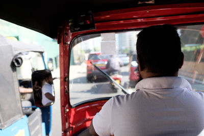 Rear view of man standing in car