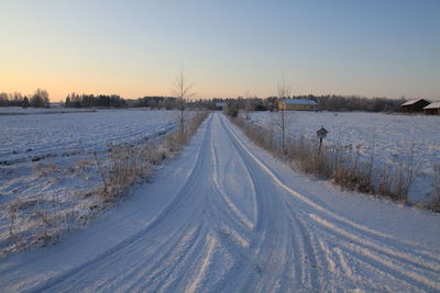 High angle view of tire tracks on snowcapped road during winter