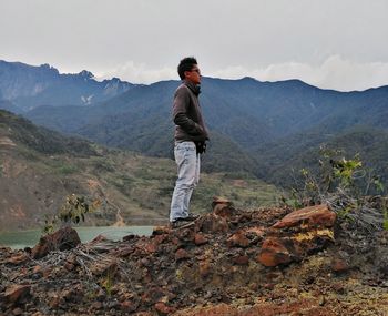 Man standing on mountain against sky