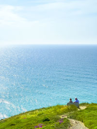 People sitting on bench at cliff