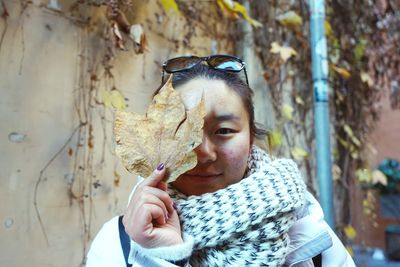 Portrait of woman holding tree trunk