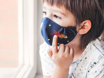 Boy with handmade mask on face. mask with embroidered space theme. quarantine coronavirus covid19.