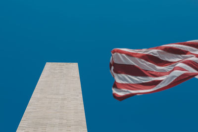 Low angle view of flag against blue sky