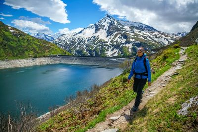 Woman hiking on footpath in the austrian alps near gastein, salzburg, austria