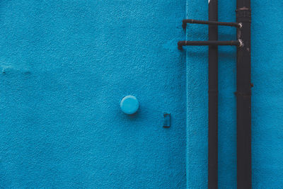 Close-up of pipes on blue wall