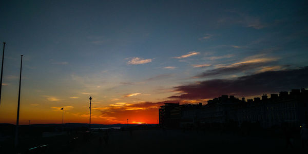 Silhouette city against sky during sunset