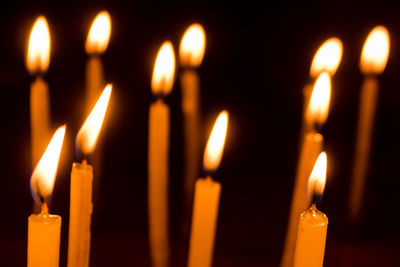 Close-up of lit candles in temple. 